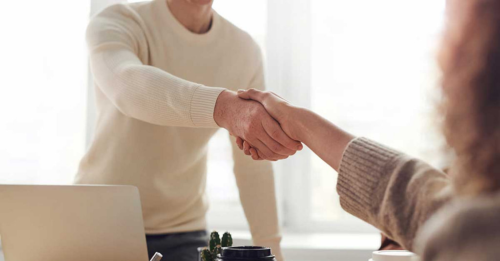 Is business coaching tax deductible - coach and client shaking hands